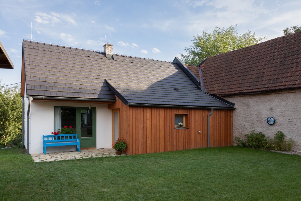 Veranda propojuje interiér se zahradou. Slouží jako přechodová zóna mezi domem a exteriérem i jako místo pro posezení během letních večerů.