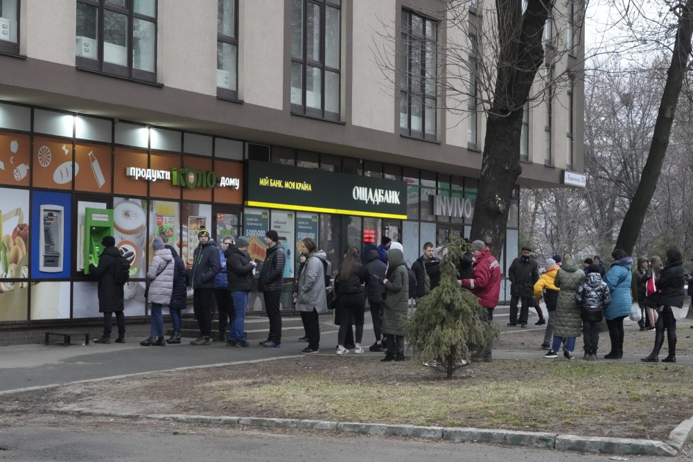 Lidé v panice vybírají peníze z bankomatů. Tvoří se před nimi fronty. 