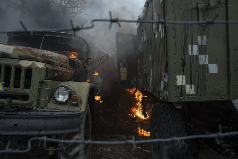 Ukrajinské vojenské vozidlo hoří po ruském útoku na Mariupol na východě Ukrajiny.