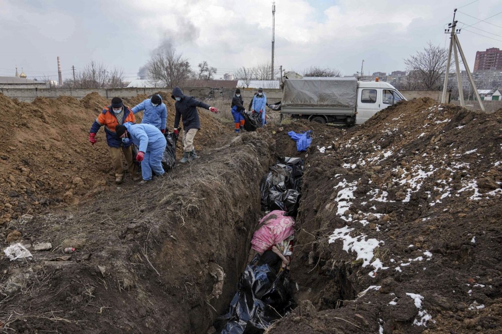 Lidé v obléhaném Mariupolu pohřbívají mrtvé do masových hrobů, 9. března 2022.