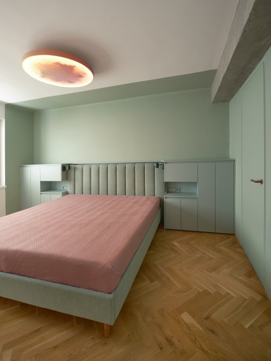 Byt v domě z 50. let v pražských Holešovicích prošel kompletní rekonstrukcí, která proměnila původně stísněnou dispozici v otevřený prostor pro mladou rodinu. Zelená centrální vestavba se šatnou a hygienickým zázemím určuje rytmus života v bytě, zatímco modré akcenty dodávají interiéru svěžest. Atmosféru dotvářejí dubové podlahy, cementové stěrky a měděné detaily.