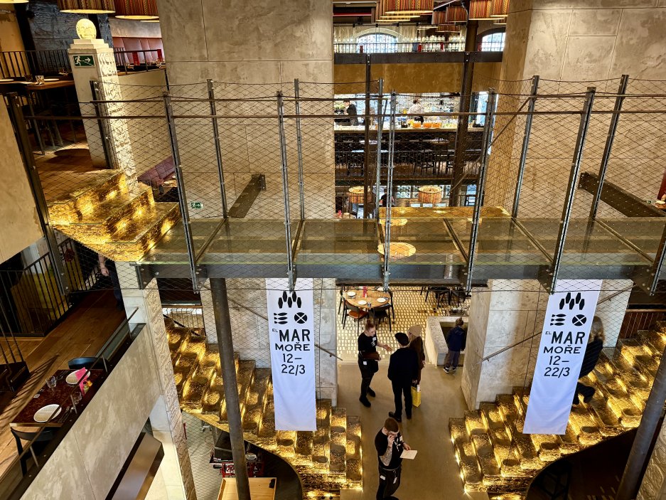 Interiér restaurace Mexická s výrazným schodištěm a centrálním barem. 
