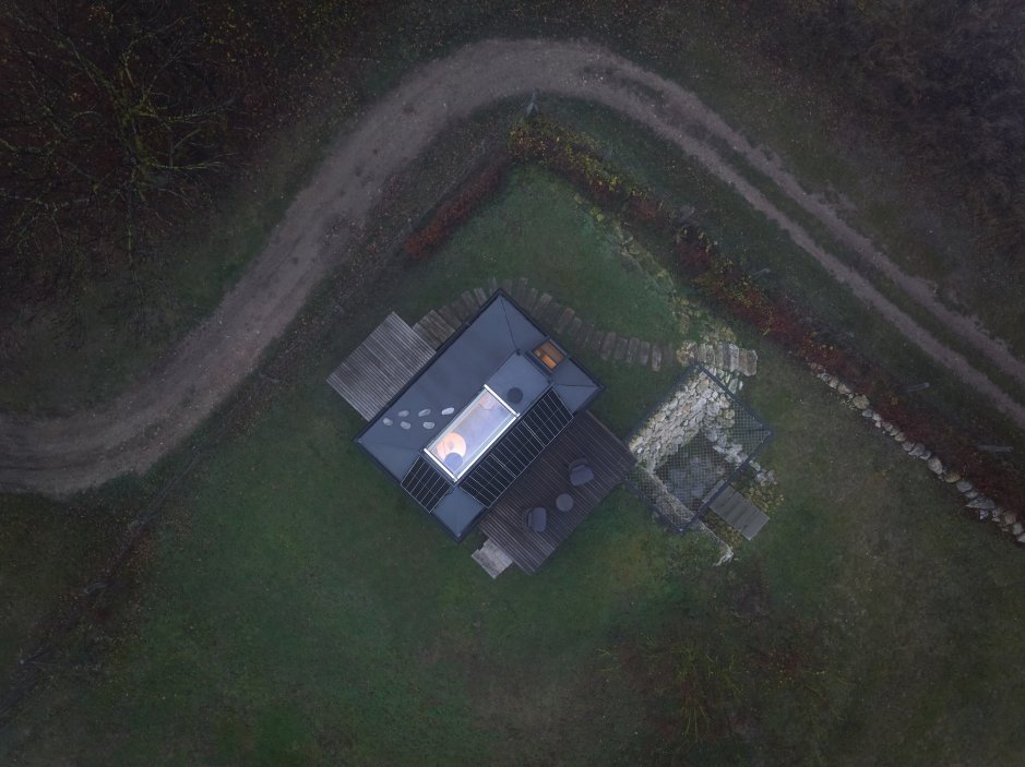 Minimalistický víkendový dům stojí na okraji vinic nad hradem Devín a nabízí jedinečné výhledy do krajiny. Díky odklápěcím fasádám se interiér otevírá do dvou teras a propojuje se s okolní přírodou. Kompaktní prostor ukrývá vše potřebné včetně kuchyně, koupelny i skrytého spaní v podkroví. Dominantním prvkem je velkoformátové zasklení, které přivádí do interiéru maximum světla.