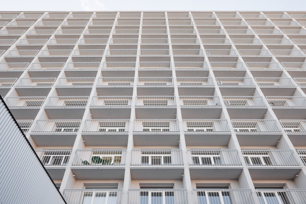Atrium Architekti zachovali výrazný betonový rastr fasády a proměnili ho v hlavní identitu domu.