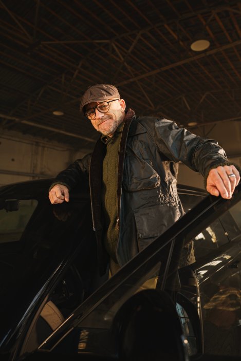 Outfitu vévodí designová voskovaná bunda, kterou vytvořil legendární britský Barbour se slavným japonským módním návrhářem Tokihitem Yoshidou, známějším jako TO KI TO. Svetr pochází ze stejné edice, kalhoty chinos pak od značky Charles Tyrwhitt.