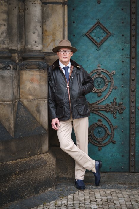 Hlavní roli outfitu hraje legendární voskovaná bunda Barbour Bedale Wax Jacket, klasické pánské džíny od značky Charles Tyrwhitt a rebelsky modré kožené rámové mokasíny Berwick Skipton.