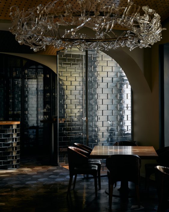 La Degustation Bohême Bourgeoise ukazuje, jak může špičková gastronomie pracovat s českou tradicí současným jazykem. Interiér studia Olgoj Chorchoj propojuje křišťál, dub, čedič i kůži a vytváří prostor, který nepůsobí okázale, ale soustředěně a sebevědomě. Dominantou je autorský lustr Consommé, jehož skleněné prvky odkazují k práci se surovinou i respektu k řemeslu.