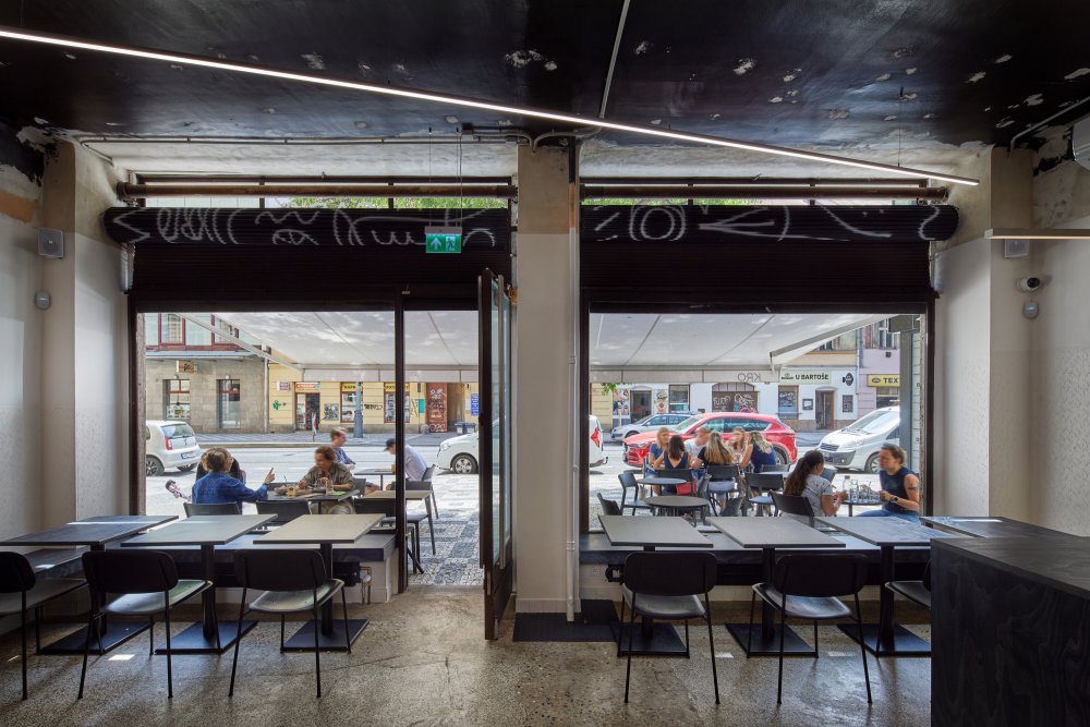Kro ukazuje, jak silně může design pracovat s identitou značky. Otevřená kuchyně, bar jako centrum dění, výrazná grafika i autorské ilustrace vytvářejí prostor, který nepůsobí jen jako restaurace, ale jako živý vizuální koncept. Právě propojení architektury, jídla a grafického rukopisu dává Kro jasně rozpoznatelnou tvář.