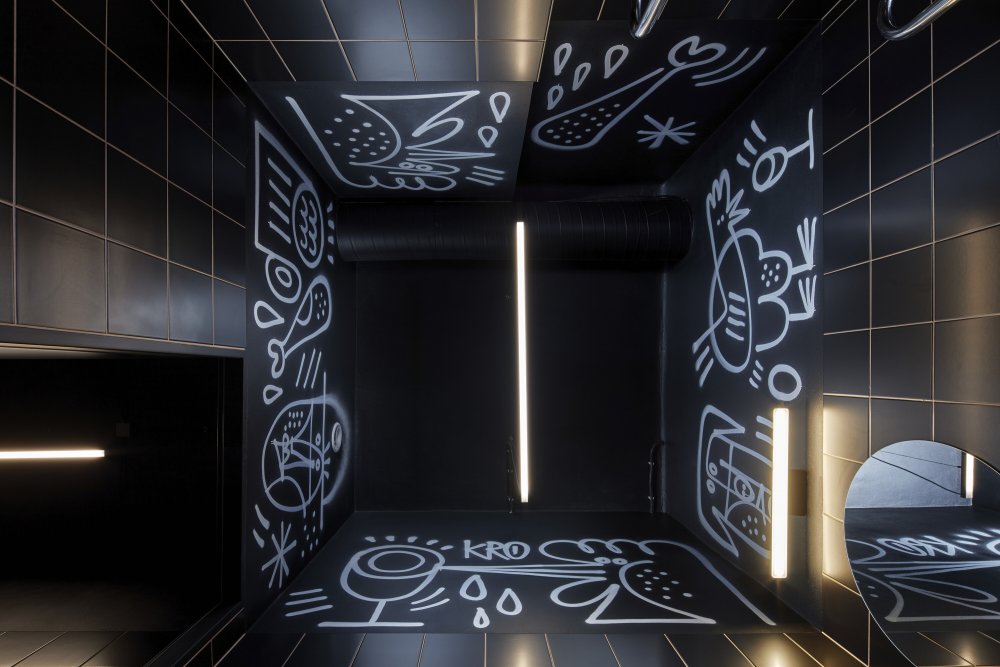 Kro ukazuje, jak silně může design pracovat s identitou značky. Otevřená kuchyně, bar jako centrum dění, výrazná grafika i autorské ilustrace vytvářejí prostor, který nepůsobí jen jako restaurace, ale jako živý vizuální koncept. Právě propojení architektury, jídla a grafického rukopisu dává Kro jasně rozpoznatelnou tvář.