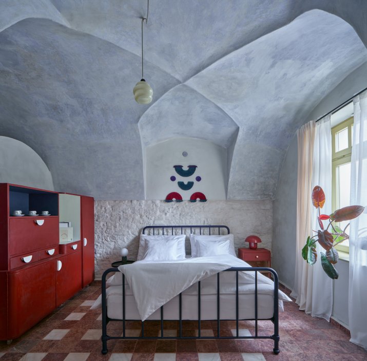 Architekti Jan a Barbora Horovi ze studia ORA proměnili rodinný dům v žatecké Obloukové ulici z téměř ztracené ruiny v místo, kde se potkává ubytování, výčep a soukromé zázemí. Rekonstrukce trvala osm let a stála na snaze zachovat maximum původních konstrukcí, využít recyklované materiály a nechat starý dům stárnout dál — jen s novým životem.