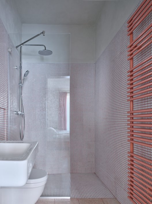 Architekti Jan a Barbora Horovi ze studia ORA proměnili rodinný dům v žatecké Obloukové ulici z téměř ztracené ruiny v místo, kde se potkává ubytování, výčep a soukromé zázemí. Rekonstrukce trvala osm let a stála na snaze zachovat maximum původních konstrukcí, využít recyklované materiály a nechat starý dům stárnout dál — jen s novým životem.