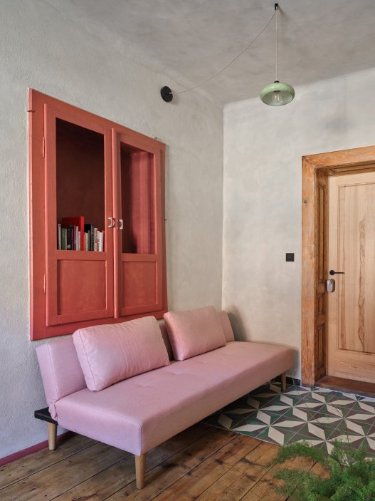 Architekti Jan a Barbora Horovi ze studia ORA proměnili rodinný dům v žatecké Obloukové ulici z téměř ztracené ruiny v místo, kde se potkává ubytování, výčep a soukromé zázemí. Rekonstrukce trvala osm let a stála na snaze zachovat maximum původních konstrukcí, využít recyklované materiály a nechat starý dům stárnout dál — jen s novým životem.