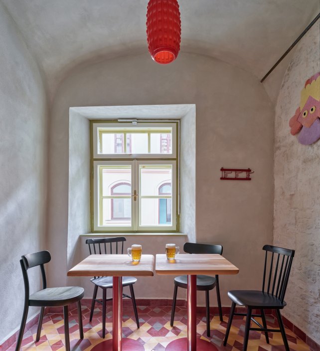Architekti Jan a Barbora Horovi ze studia ORA proměnili rodinný dům v žatecké Obloukové ulici z téměř ztracené ruiny v místo, kde se potkává ubytování, výčep a soukromé zázemí. Rekonstrukce trvala osm let a stála na snaze zachovat maximum původních konstrukcí, využít recyklované materiály a nechat starý dům stárnout dál — jen s novým životem.