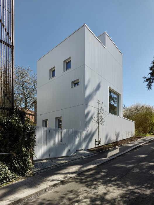 Bílý kvádr v pražské proluce ukazuje, že kvalitní architektura nevzniká velikostí, ale přesností návrhu. Rodinný dům Minimální maximum od ateliéru Stempel Tesař architekti pracuje s extrémně omezeným pozemkem, posunutými podlažími, absencí chodby a výrazným kontrastem bílé hliníkové fasády, pohledového betonu a ořechového dřeva. Stavba nominovaná na Českou cenu za architekturu je ukázkou toho, jak lze z minima prostoru vytvořit plnohodnotný, promyšlený a výtvarně silný domov.