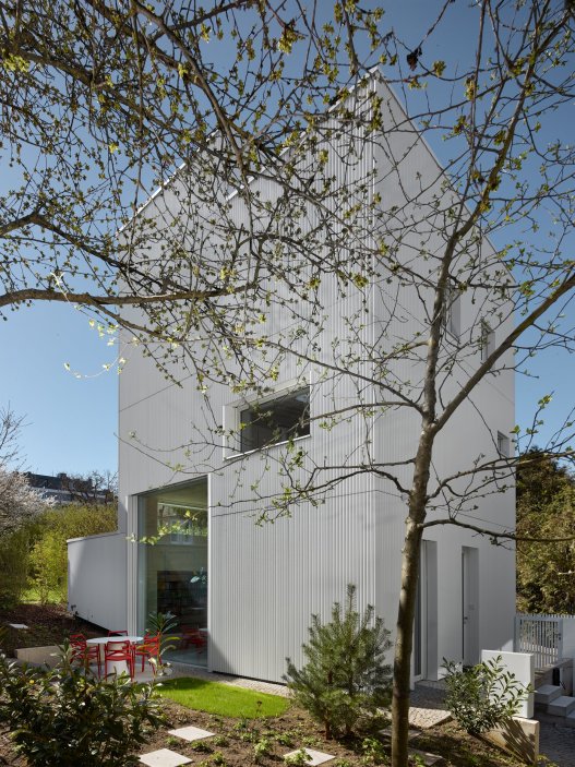 Bílý kvádr v pražské proluce ukazuje, že kvalitní architektura nevzniká velikostí, ale přesností návrhu. Rodinný dům Minimální maximum od ateliéru Stempel Tesař architekti pracuje s extrémně omezeným pozemkem, posunutými podlažími, absencí chodby a výrazným kontrastem bílé hliníkové fasády, pohledového betonu a ořechového dřeva. Stavba nominovaná na Českou cenu za architekturu je ukázkou toho, jak lze z minima prostoru vytvořit plnohodnotný, promyšlený a výtvarně silný domov.