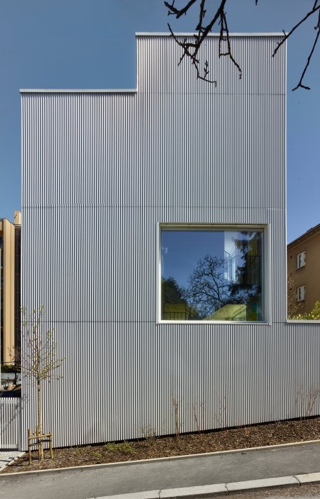 Bílý kvádr v pražské proluce ukazuje, že kvalitní architektura nevzniká velikostí, ale přesností návrhu. Rodinný dům Minimální maximum od ateliéru Stempel Tesař architekti pracuje s extrémně omezeným pozemkem, posunutými podlažími, absencí chodby a výrazným kontrastem bílé hliníkové fasády, pohledového betonu a ořechového dřeva. Stavba nominovaná na Českou cenu za architekturu je ukázkou toho, jak lze z minima prostoru vytvořit plnohodnotný, promyšlený a výtvarně silný domov.