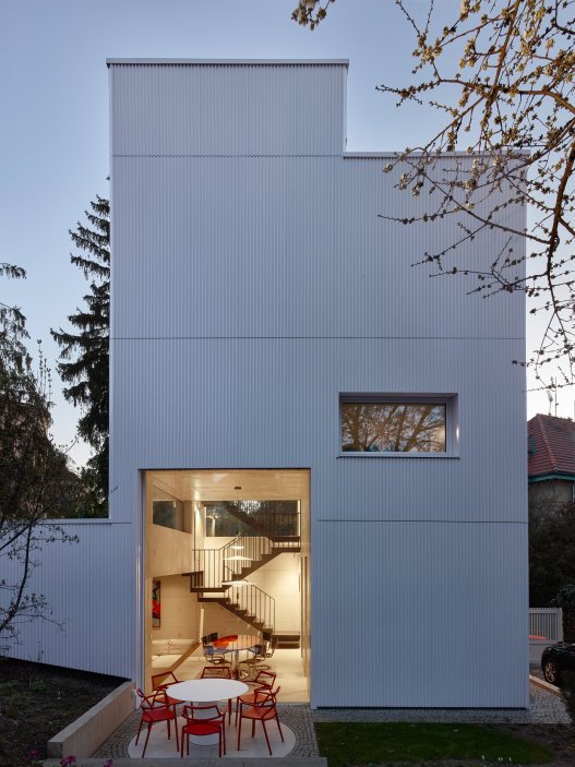 Bílý kvádr v pražské proluce ukazuje, že kvalitní architektura nevzniká velikostí, ale přesností návrhu. Rodinný dům Minimální maximum od ateliéru Stempel Tesař architekti pracuje s extrémně omezeným pozemkem, posunutými podlažími, absencí chodby a výrazným kontrastem bílé hliníkové fasády, pohledového betonu a ořechového dřeva. Stavba nominovaná na Českou cenu za architekturu je ukázkou toho, jak lze z minima prostoru vytvořit plnohodnotný, promyšlený a výtvarně silný domov.