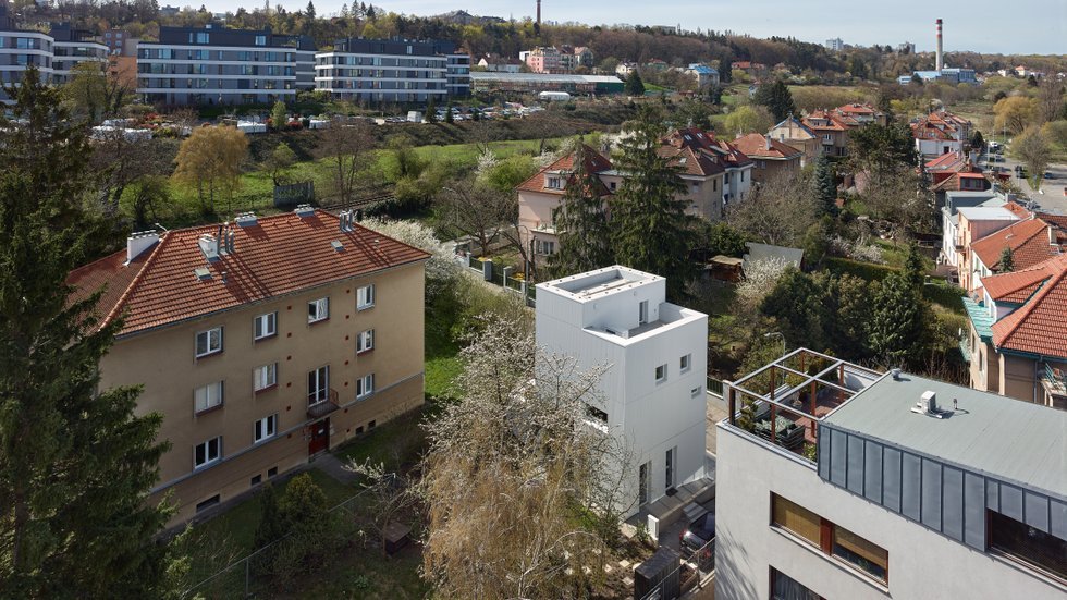 Bílý kvádr v pražské proluce ukazuje, že kvalitní architektura nevzniká velikostí, ale přesností návrhu. Rodinný dům Minimální maximum od ateliéru Stempel Tesař architekti pracuje s extrémně omezeným pozemkem, posunutými podlažími, absencí chodby a výrazným kontrastem bílé hliníkové fasády, pohledového betonu a ořechového dřeva. Stavba nominovaná na Českou cenu za architekturu je ukázkou toho, jak lze z minima prostoru vytvořit plnohodnotný, promyšlený a výtvarně silný domov.