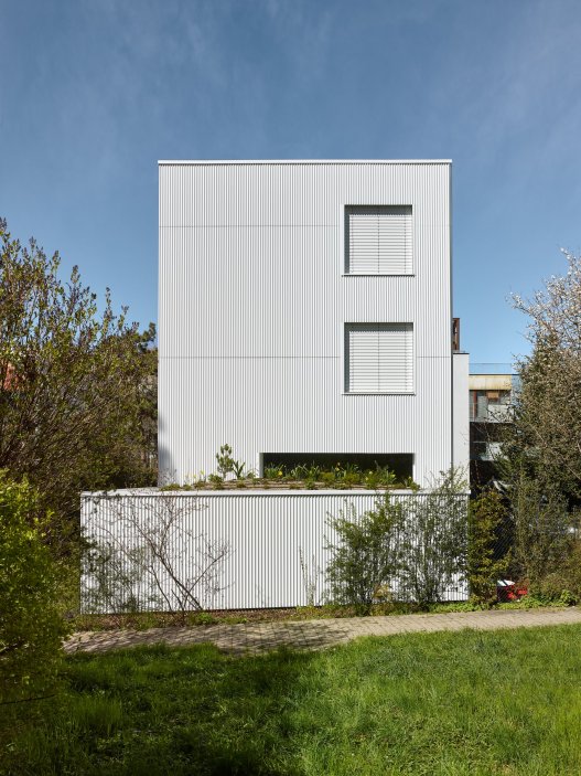 Bílý kvádr v pražské proluce ukazuje, že kvalitní architektura nevzniká velikostí, ale přesností návrhu. Rodinný dům Minimální maximum od ateliéru Stempel Tesař architekti pracuje s extrémně omezeným pozemkem, posunutými podlažími, absencí chodby a výrazným kontrastem bílé hliníkové fasády, pohledového betonu a ořechového dřeva. Stavba nominovaná na Českou cenu za architekturu je ukázkou toho, jak lze z minima prostoru vytvořit plnohodnotný, promyšlený a výtvarně silný domov.