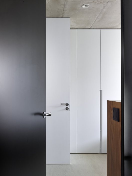 Bílý kvádr v pražské proluce ukazuje, že kvalitní architektura nevzniká velikostí, ale přesností návrhu. Rodinný dům Minimální maximum od ateliéru Stempel Tesař architekti pracuje s extrémně omezeným pozemkem, posunutými podlažími, absencí chodby a výrazným kontrastem bílé hliníkové fasády, pohledového betonu a ořechového dřeva. Stavba nominovaná na Českou cenu za architekturu je ukázkou toho, jak lze z minima prostoru vytvořit plnohodnotný, promyšlený a výtvarně silný domov.