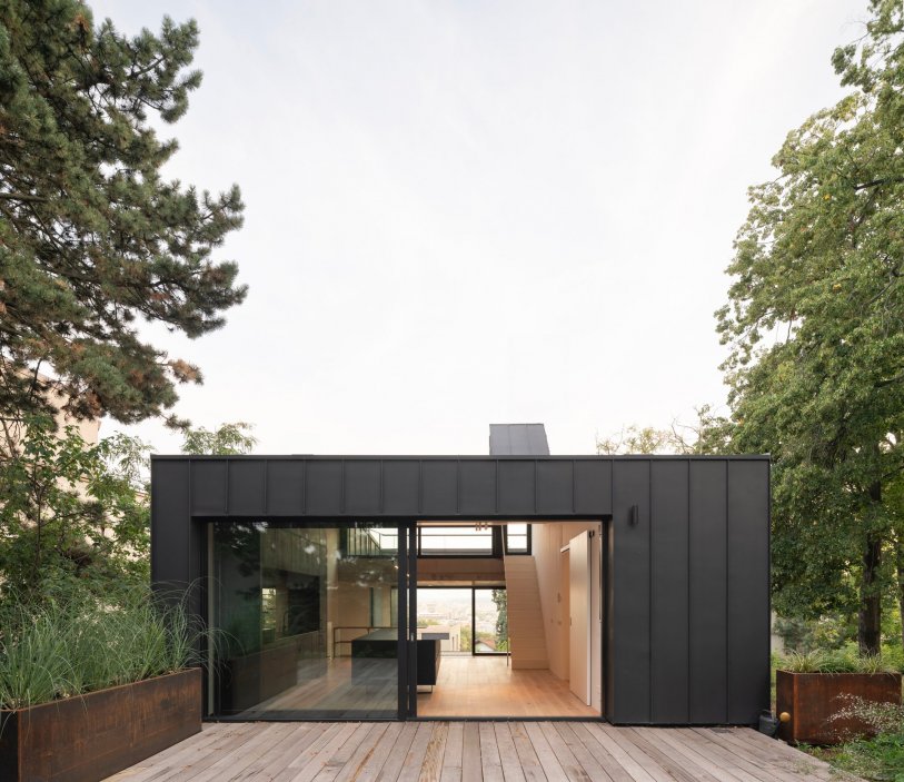 Black House stojí na jižním svahu Kobyliské plošiny a využívá jednu z největších předností parcely — panoramatický výhled na pražskou kotlinu.