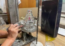 Ve sklárně se stále fouká sklo tradiční píšťalou, výrobky se odlévají do dřevěných forem a zkušená kreslička před broušením ručně vyznačuje každý řez. Za historickou kulisou se však odehrává tvrdý průmyslový byznys
