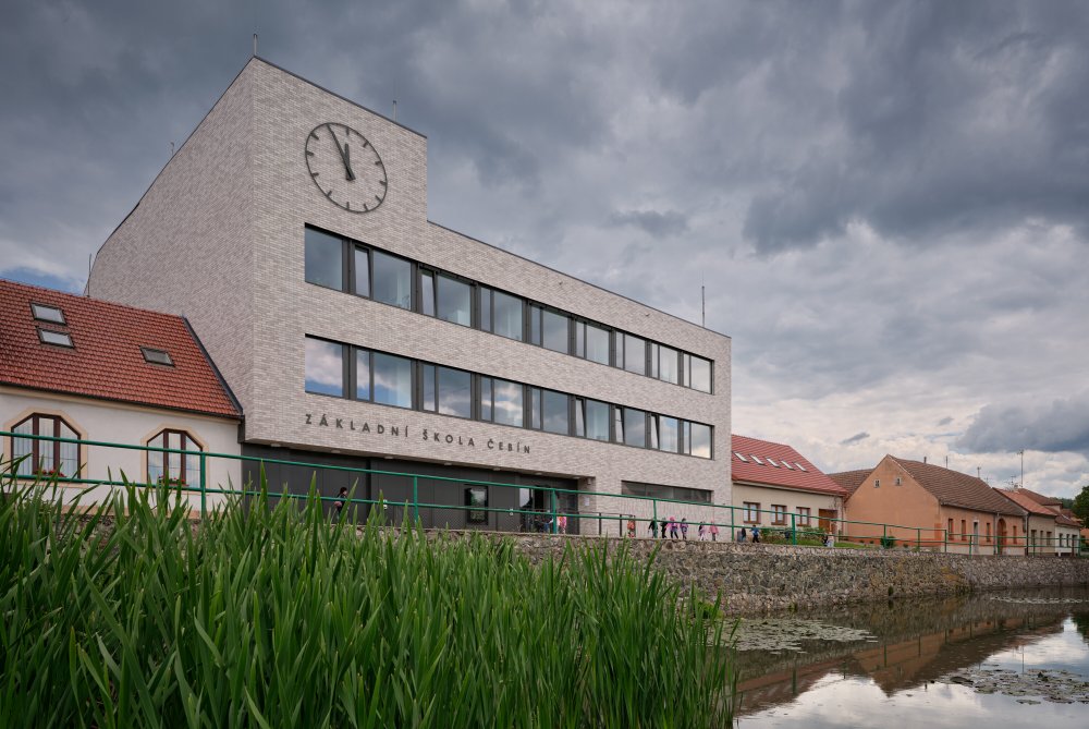 Bývalý obchodní dům Jednota ze 70. let dostal v Čebíně nový život. Brněnské studio knesl kynčl architekti jej proměnilo v moderní školu pro zhruba 120 žáků, která doplnila chybějící druhý stupeň a stala se novou součástí života na návsi. Projekt ukazuje, že i zdánlivě přežité stavby mohou místo demolice získat smysluplnou současnou funkci.