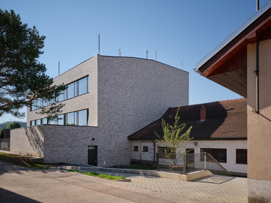 Bývalý obchodní dům Jednota ze 70. let dostal v Čebíně nový život. Brněnské studio knesl kynčl architekti jej proměnilo v moderní školu pro zhruba 120 žáků, která doplnila chybějící druhý stupeň a stala se novou součástí života na návsi. Projekt ukazuje, že i zdánlivě přežité stavby mohou místo demolice získat smysluplnou současnou funkci.
