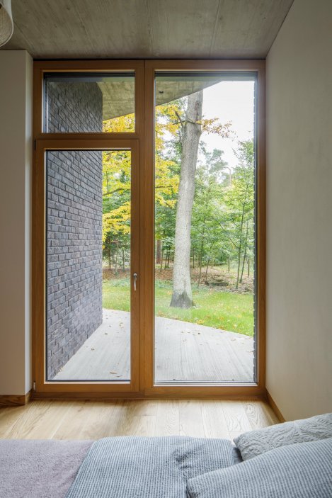 Na první pohled působí jako kruhový dům, uvnitř je ale překvapivě racionální. Novostavba ateliéru OVA v Kersku skládá obytné kvádry pod velkorysou kruhovou střechou a mezi borovicemi hledá rovnováhu mezi vilou a chatou.