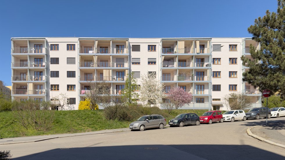 Revitalizace panelového domu v pražských Strašnicích ukazuje, že proměna nemusí stát na křiklavé fasádě. Architekt Radek Novotný dům doplnil o větší lodžie, francouzská okna a nové stínění, které zvyšují komfort bydlení a zároveň dávají domu současnější, kultivovanější výraz.