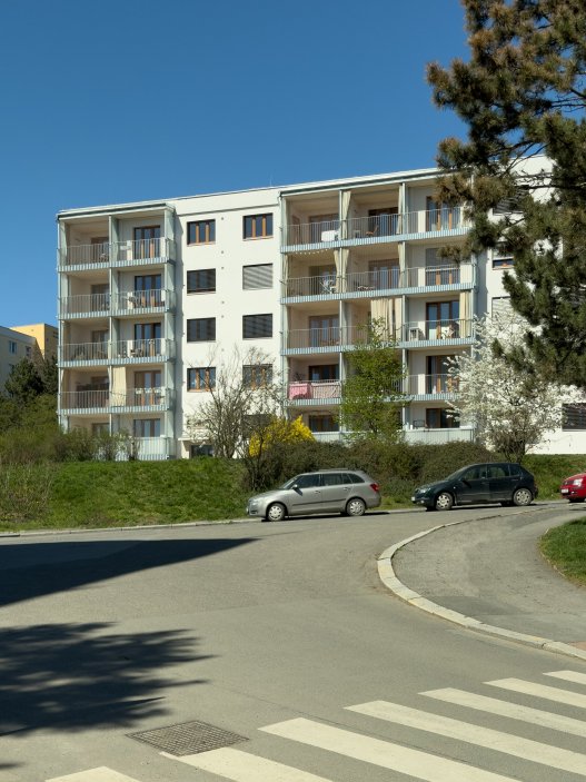 Revitalizace panelového domu v pražských Strašnicích ukazuje, že proměna nemusí stát na křiklavé fasádě. Architekt Radek Novotný dům doplnil o větší lodžie, francouzská okna a nové stínění, které zvyšují komfort bydlení a zároveň dávají domu současnější, kultivovanější výraz.