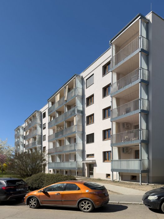 Revitalizace panelového domu v pražských Strašnicích ukazuje, že proměna nemusí stát na křiklavé fasádě. Architekt Radek Novotný dům doplnil o větší lodžie, francouzská okna a nové stínění, které zvyšují komfort bydlení a zároveň dávají domu současnější, kultivovanější výraz.