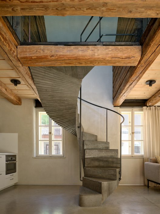 Bukovanský domeček od studia SENAA ukazuje, jak může současná architektura fungovat v historickém vesnickém prostředí. Novostavba respektuje původní stopu domu i charakter úzké vinařské uličky, uvnitř ale nabízí moderní dispozici, velkoformátová okna, betonové schodiště i staré trámy zachráněné z pražského Karlína.