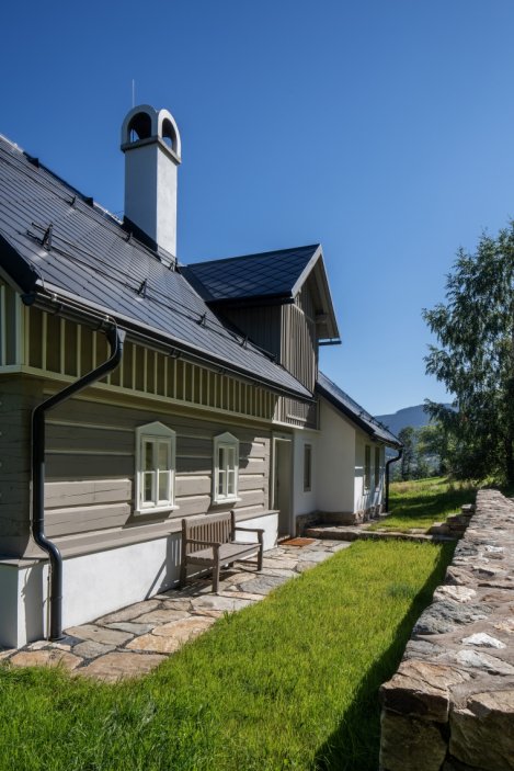 Stará krkonošská roubenka v Rokytnici nad Jizerou prošla citlivou rekonstrukcí, která zachovala maximum původních prvků a zároveň ji přizpůsobila současnému bydlení. Uvnitř vznikly tři apartmány, sauna a nové zázemí, dům si ale ponechal své nepravidelnosti, původní kámen i charakter horské chalupy. Za proměnou stojí architektka Barbora Šlechta Vlčková a studio BARAAK Architects.
