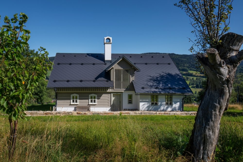 Stará krkonošská roubenka v Rokytnici nad Jizerou prošla citlivou rekonstrukcí, která zachovala maximum původních prvků a zároveň ji přizpůsobila současnému bydlení. Uvnitř vznikly tři apartmány, sauna a nové zázemí, dům si ale ponechal své nepravidelnosti, původní kámen i charakter horské chalupy. Za proměnou stojí architektka Barbora Šlechta Vlčková a studio BARAAK Architects.