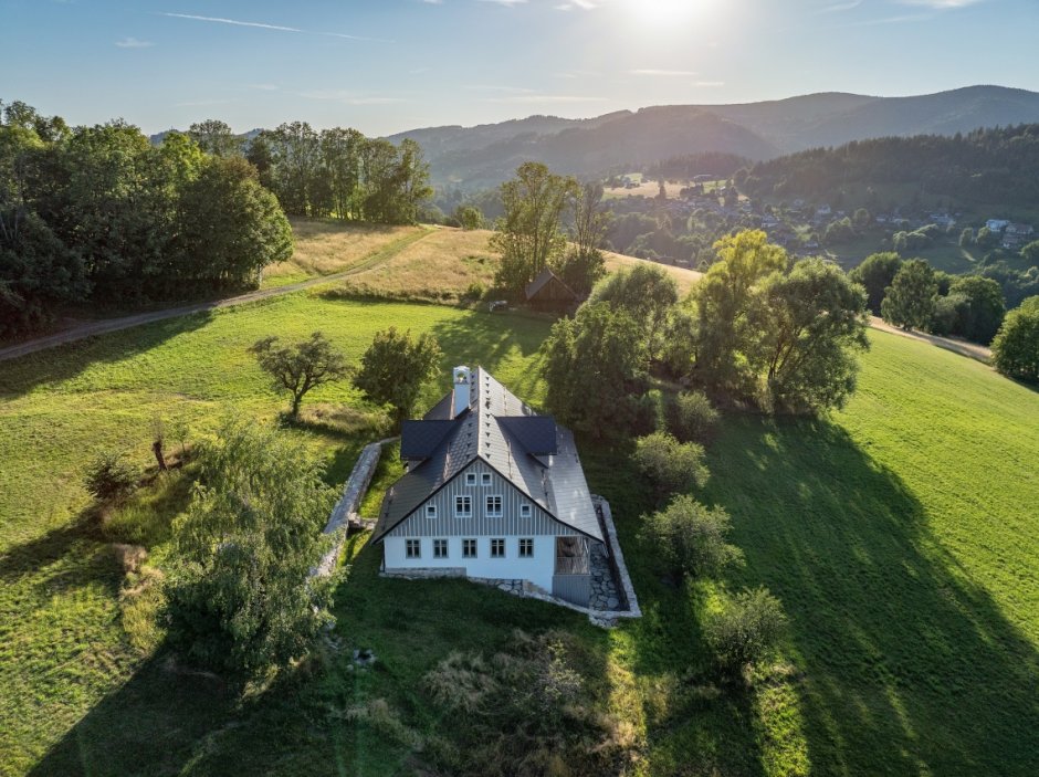 Stará krkonošská roubenka v Rokytnici nad Jizerou prošla citlivou rekonstrukcí, která zachovala maximum původních prvků a zároveň ji přizpůsobila současnému bydlení. Uvnitř vznikly tři apartmány, sauna a nové zázemí, dům si ale ponechal své nepravidelnosti, původní kámen i charakter horské chalupy. Za proměnou stojí architektka Barbora Šlechta Vlčková a studio BARAAK Architects.