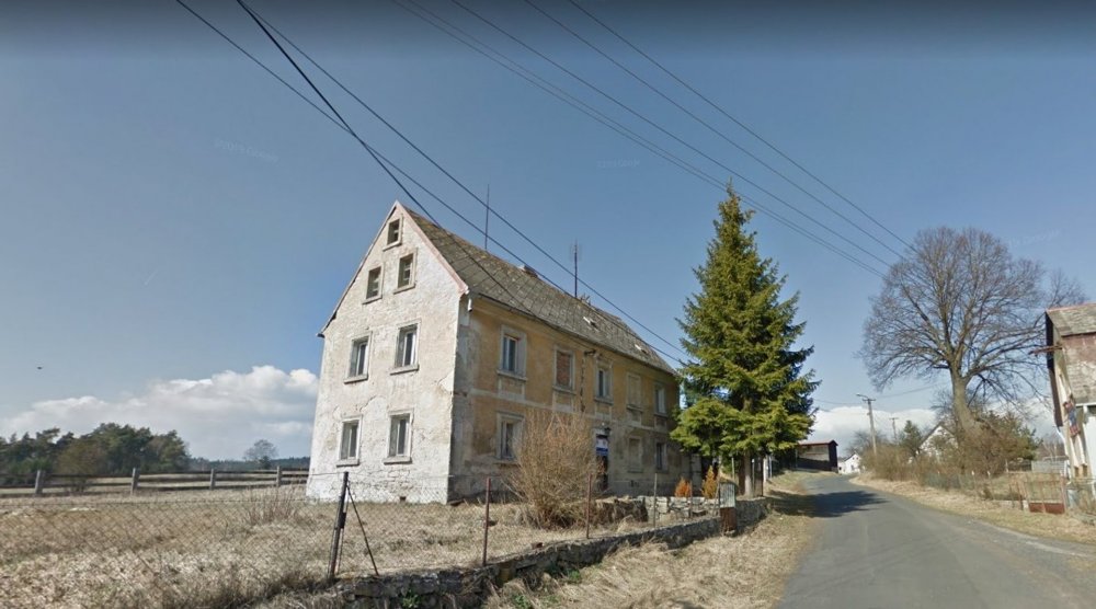 V Lipné u Hazlova, v krajině bývalých Sudet nedaleko německých hranic, stojí vedle sebe roubený statek po babičce majitele a kamenný dům z roku 1852. Obě stavby prošly citlivou obnovou, která zachovala původní dřevo a kámen a doplnila je současnou architekturou. Dnes tvoří komorní areál, kde hlavní roli hrají historie, krajina a klid.