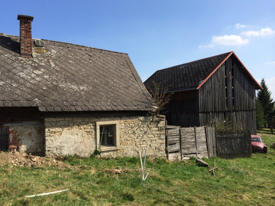 V Lipné u Hazlova, v krajině bývalých Sudet nedaleko německých hranic, stojí vedle sebe roubený statek po babičce majitele a kamenný dům z roku 1852. Obě stavby prošly citlivou obnovou, která zachovala původní dřevo a kámen a doplnila je současnou architekturou. Dnes tvoří komorní areál, kde hlavní roli hrají historie, krajina a klid.