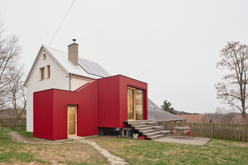 Z chlívku chatka, z chatky dům s výrazným červeným přístavkem. Facha architekti proměnili stavení v Nečíni, otevřeli ho do zahrady a doplnili modřínovou terasou. Prohlédněte si, jak červený vlnitý plech, borová překližka a temně modrá podlaha daly starému domku novou podobu.