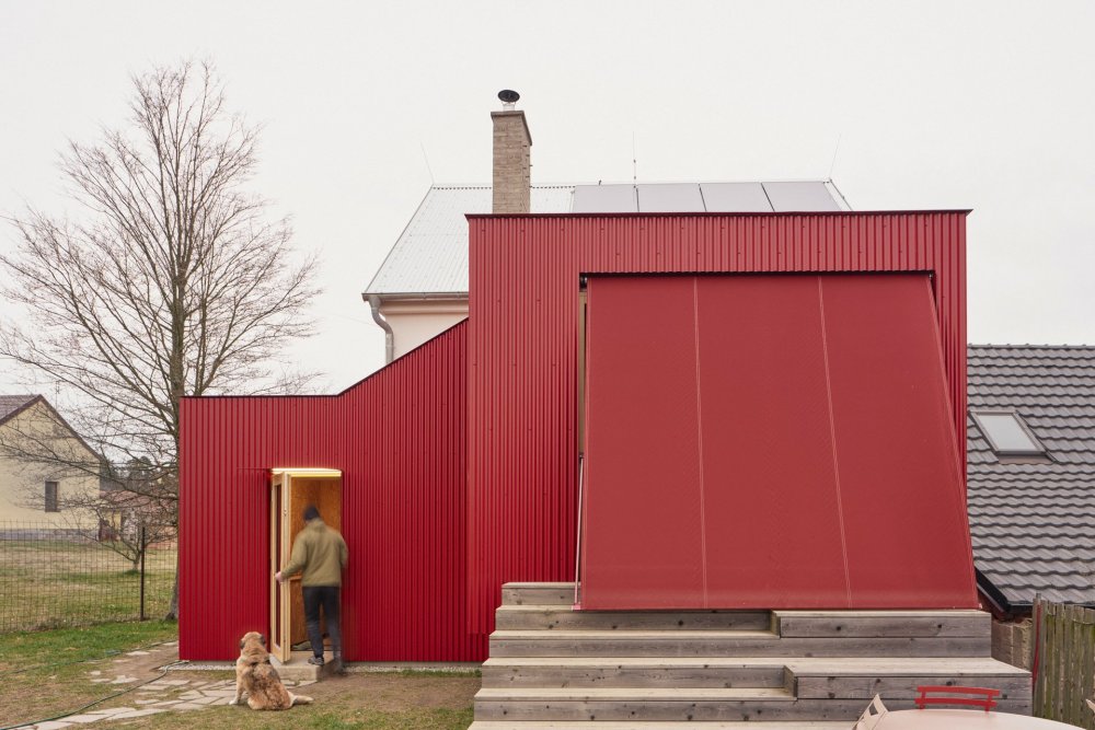 Z chlívku chatka, z chatky dům s výrazným červeným přístavkem. Facha architekti proměnili stavení v Nečíni, otevřeli ho do zahrady a doplnili modřínovou terasou. Prohlédněte si, jak červený vlnitý plech, borová překližka a temně modrá podlaha daly starému domku novou podobu.