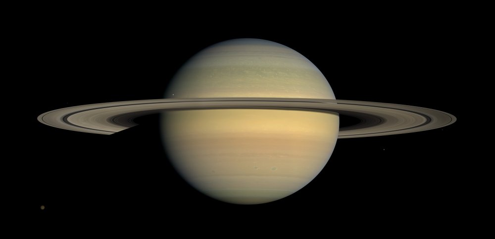 Planeta Saturn s prstenci složenými z měsíců, mezi nimiž je i tajuplná Enceladus.