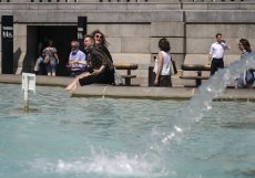 Lidé se chladí ve slavné fontáně na Trafalgarském náměstí v Londýně.