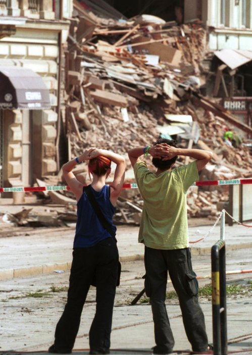 Dvojice mladých lidí hledí na zbytky zříceného domu v pražském Karlíně (18. srpna 2002).