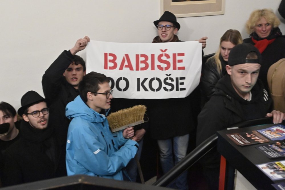 Odpůrci Andreje Babiše demonstrují s transparentem v hotelu, kde prezidentský kandidát a předseda hnutí ANO diskutoval s občany, 19. ledna 2023, Benešov.