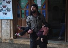 Syřan vynáší z budovy mladou dívku ve městě Azmarin v provincii Idlib na severu Sýrie.