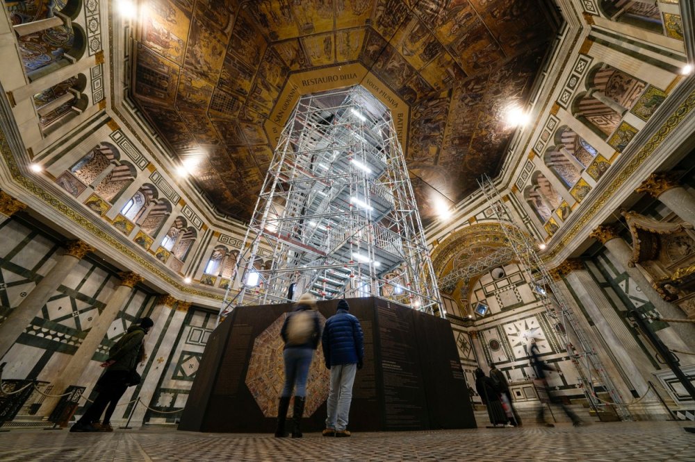 Návštěvníci obdivují křtitelnici sv. Jana v jednom z nejstarších kostelů ve Florencii ve střední Itálii, úterý 7. února 2023. Kopule prochází restaurátorskými pracemi, které návštěvníkům umožní stanout tváří v tvář více než 1000 čtverečních metrů vzácných mozaik pokrývajících kopuli.