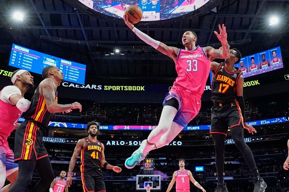 Téměř taneční umění. Basketbalista Washingtonu Wizards Kyle Kuzma (33) dává ve výskoku koš před útočníkem Atlanty Hawks Onyekou Okongwu (17) během prvního poločasu zápasu basketbalové NBA ve středu 8. března 2023 ve Washingtonu. Hawks vyhráli 122:120. 