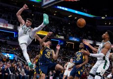 Fotogenický basketbal. Obránce Milwaukee Bucks Grayson Allen (12) byl faulován útočníkem Indiana Pacers Jordanem Nworou (13) během druhé poloviny zápasu basketbalové NBA v Indianapolis, středa 29. března 2023.