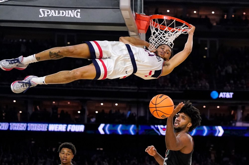 A zase ten basket. Obránce Connecticutu Andre Jackson Jr. nahazuje míč přes útočníka Miami Norchada Omiera během druhé poloviny basketbalového zápasu Final Four na turnaji NCAA v Houstonu, v sobotu 1. dubna 2023. 