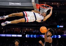 A zase ten basket. Obránce Connecticutu Andre Jackson Jr. nahazuje míč přes útočníka Miami Norchada Omiera během druhé poloviny basketbalového zápasu Final Four na turnaji NCAA v Houstonu, v sobotu 1. dubna 2023. 